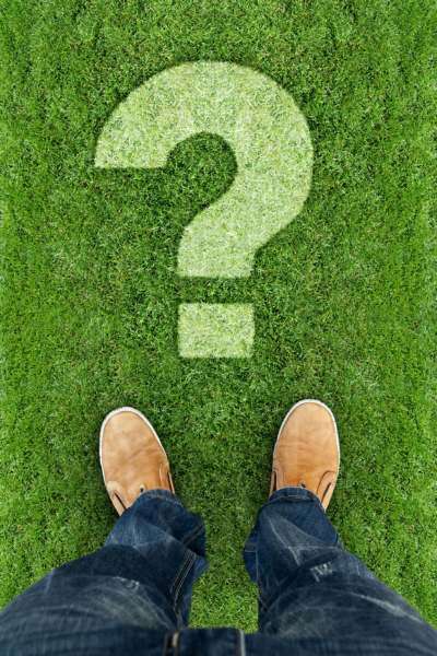 A person standing on grass with a large question mark overlayed.