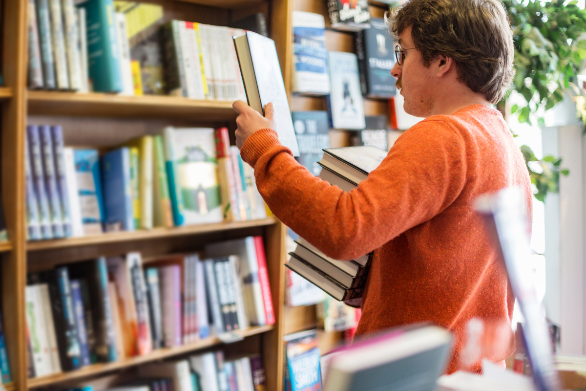 Man choosing a book to buy in a bookshop